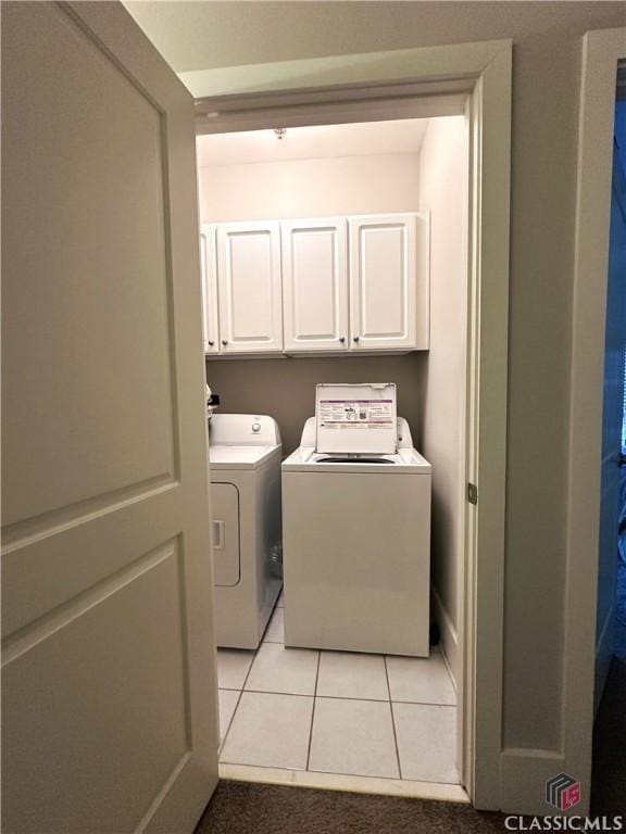 laundry area with light tile patterned flooring, cabinets, and separate washer and dryer