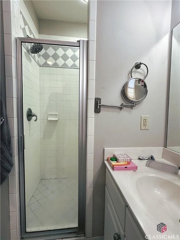 bathroom featuring vanity and a shower with shower door