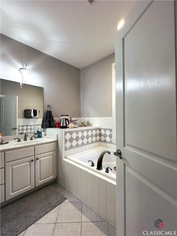 bathroom featuring vanity, tiled bath, and tile patterned floors