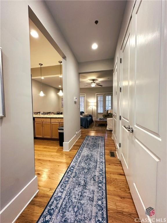 corridor with light hardwood / wood-style flooring