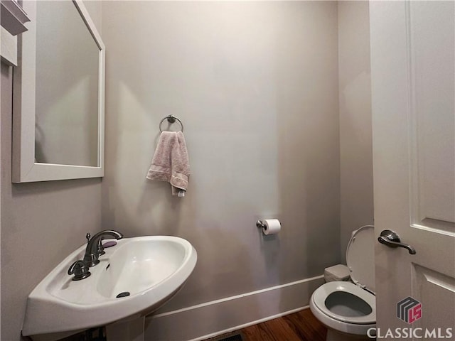 bathroom featuring sink, hardwood / wood-style floors, and toilet