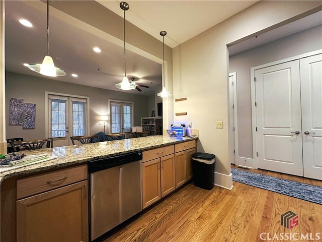 kitchen with pendant lighting, stainless steel dishwasher, french doors, and dark stone counters