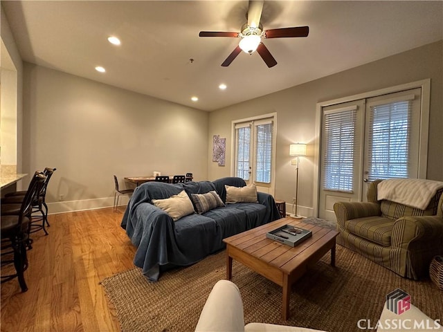 living room with ceiling fan, plenty of natural light, and light hardwood / wood-style flooring