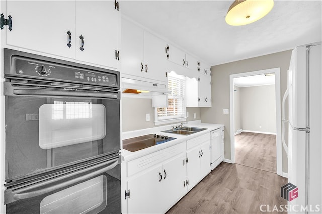 kitchen with white cabinets, sink, light wood-type flooring, and black appliances