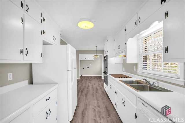 kitchen with white cabinetry, sink, pendant lighting, and black appliances