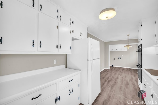 kitchen featuring pendant lighting, white cabinetry, double oven, white refrigerator, and light hardwood / wood-style floors