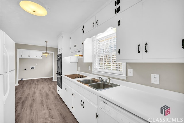 kitchen with hanging light fixtures, sink, white cabinets, and black appliances