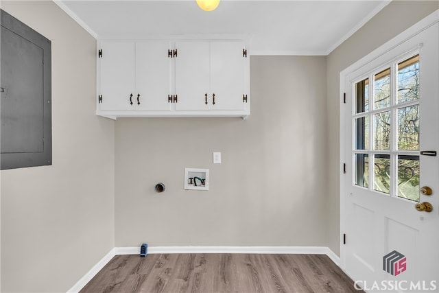 washroom featuring cabinets, ornamental molding, washer hookup, electric panel, and light hardwood / wood-style flooring