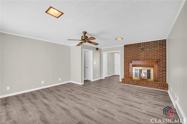 unfurnished living room with crown molding, hardwood / wood-style flooring, a fireplace, and ceiling fan