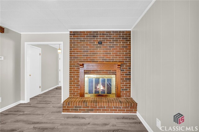 unfurnished living room featuring crown molding, wood-type flooring, and a fireplace