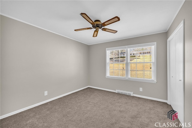 carpeted spare room with ornamental molding and ceiling fan