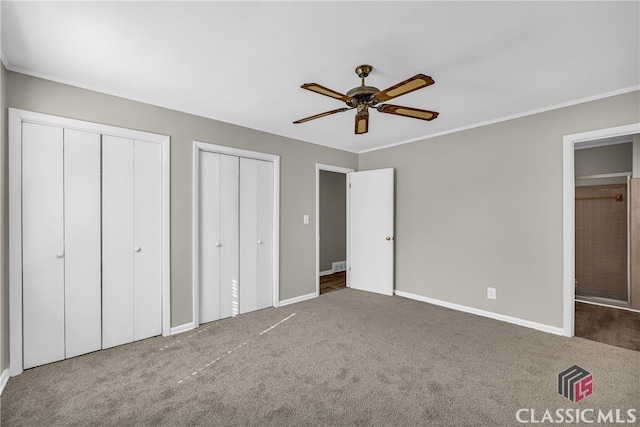 unfurnished bedroom with multiple closets, ceiling fan, and carpet floors