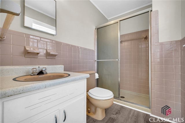 bathroom featuring tile walls, toilet, hardwood / wood-style flooring, walk in shower, and crown molding