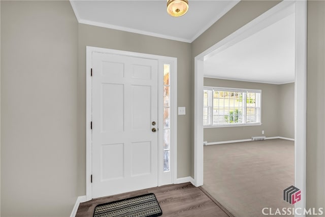 carpeted foyer entrance with crown molding