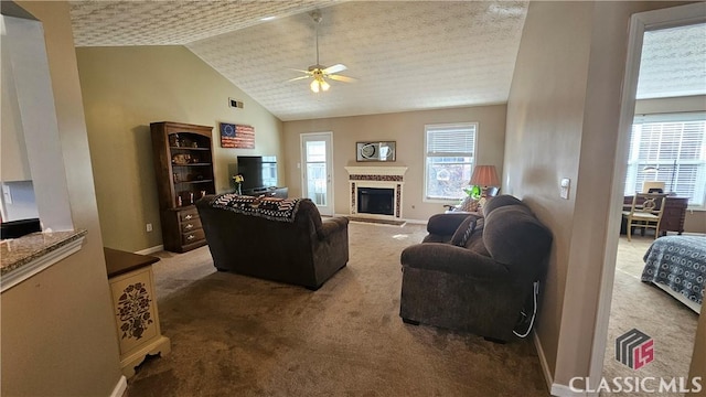 living room with carpet floors, vaulted ceiling, ceiling fan, and plenty of natural light