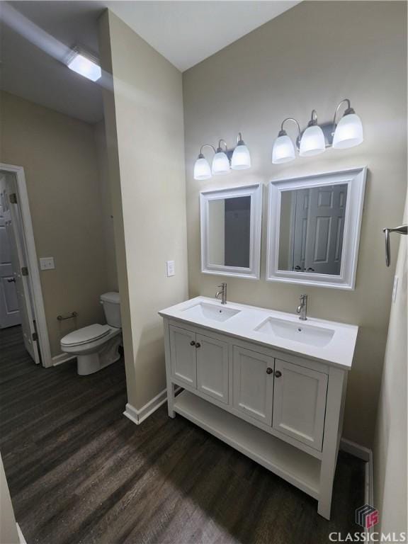 bathroom with vanity, toilet, and hardwood / wood-style floors