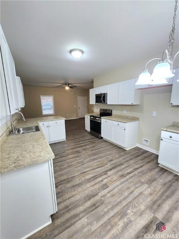 kitchen featuring sink, white cabinetry, hanging light fixtures, stainless steel appliances, and kitchen peninsula