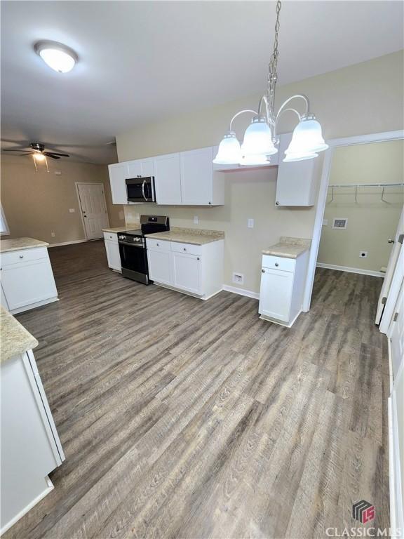 kitchen featuring white cabinetry, stainless steel appliances, and decorative light fixtures