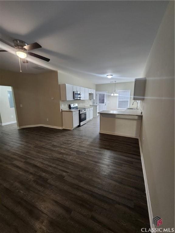 unfurnished living room featuring dark hardwood / wood-style flooring and ceiling fan