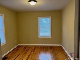 empty room with hardwood / wood-style flooring