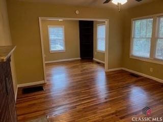 unfurnished living room featuring dark hardwood / wood-style floors and ceiling fan