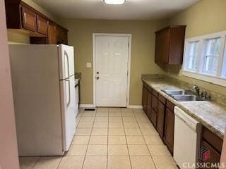 kitchen featuring white appliances, sink, and light tile patterned floors