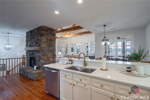 kitchen featuring sink, white cabinetry, a chandelier, dishwasher, and pendant lighting