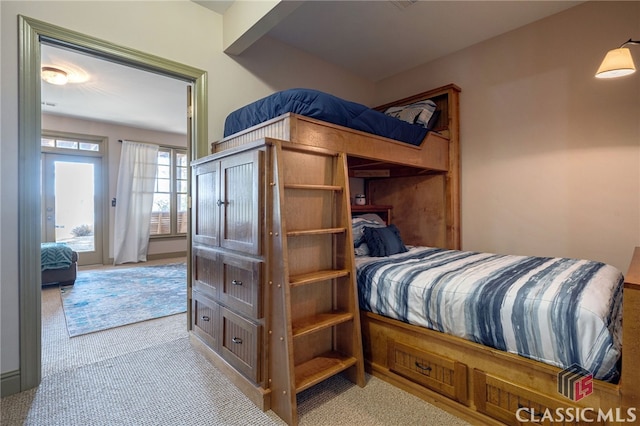 bedroom with light colored carpet and access to outside