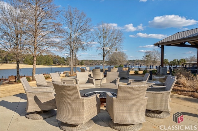 view of patio with a water view and an outdoor fire pit