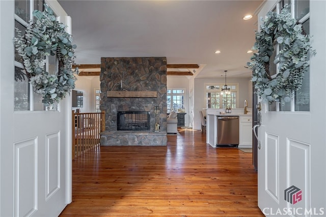 living room with hardwood / wood-style floors, a fireplace, and beamed ceiling