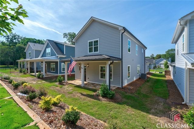 view of front of house with central AC unit, a front yard, and covered porch