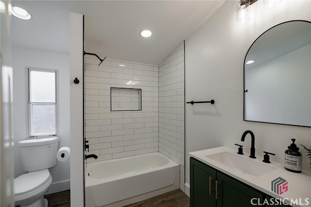 full bathroom with vanity, tiled shower / bath combo, wood-type flooring, and toilet