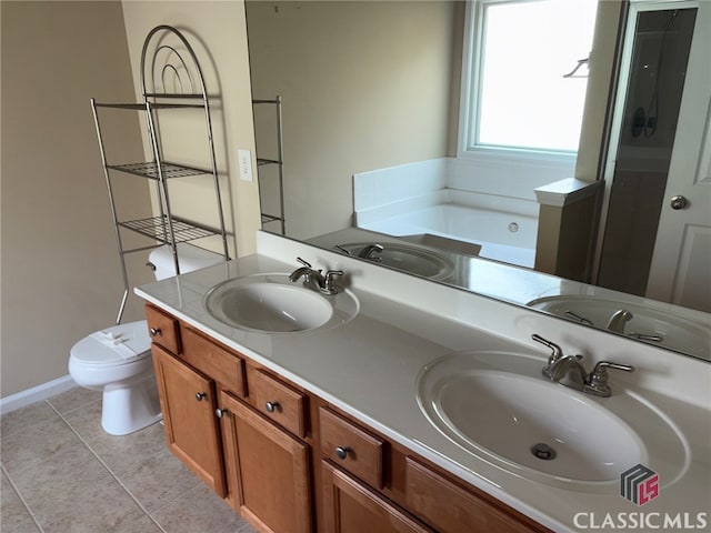 bathroom featuring tile patterned floors, a tub to relax in, toilet, and vanity