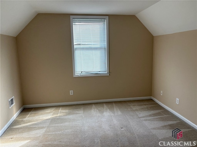 bonus room featuring vaulted ceiling and light colored carpet