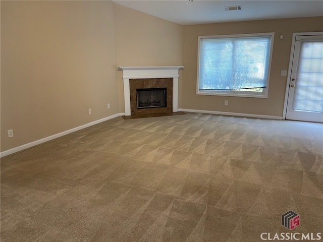 unfurnished living room with lofted ceiling, light carpet, and a fireplace