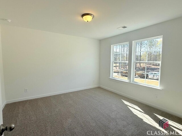 empty room featuring visible vents and baseboards