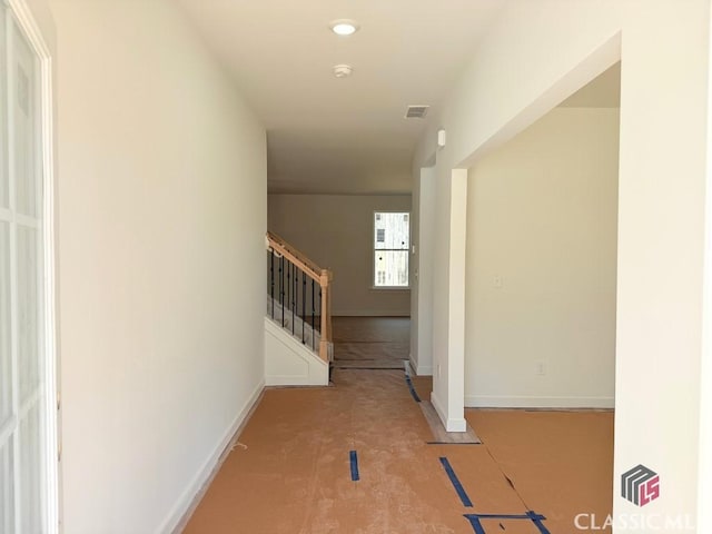 corridor with stairs, visible vents, and baseboards