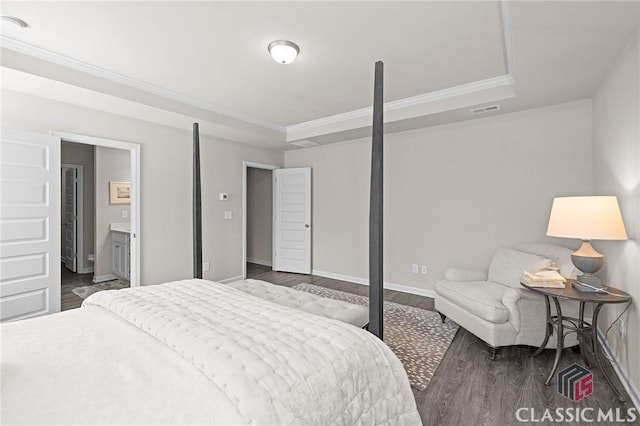 bedroom with visible vents, baseboards, dark wood finished floors, ornamental molding, and a raised ceiling