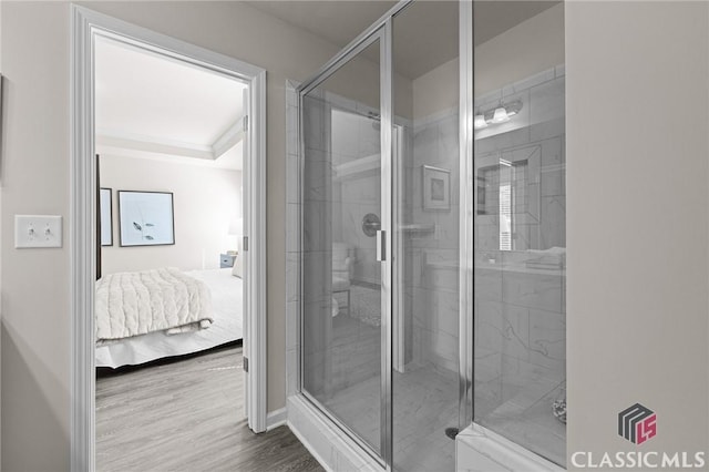 bathroom featuring ensuite bath, wood finished floors, and a stall shower