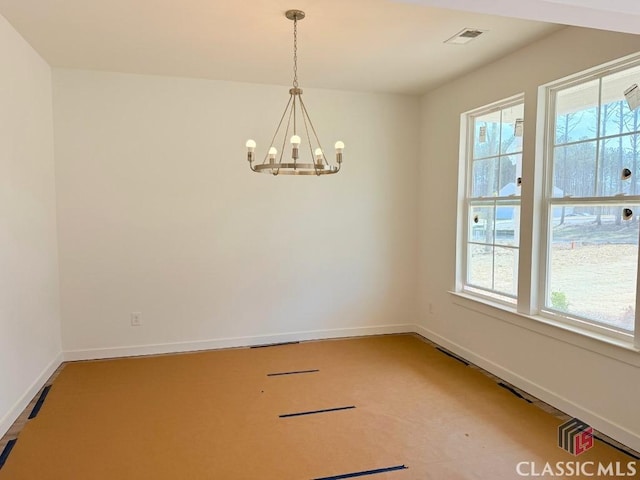 carpeted spare room with visible vents, baseboards, and a notable chandelier