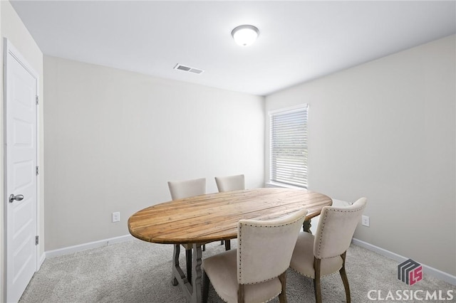 carpeted dining space featuring visible vents and baseboards