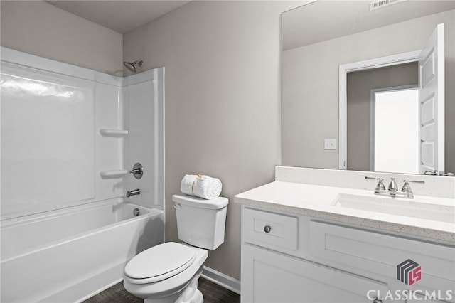 bathroom with visible vents, toilet, wood finished floors, bathing tub / shower combination, and vanity