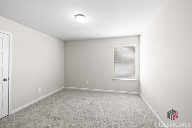 spare room featuring visible vents, baseboards, and carpet flooring