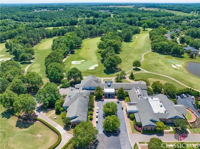 aerial view featuring a forest view and view of golf course