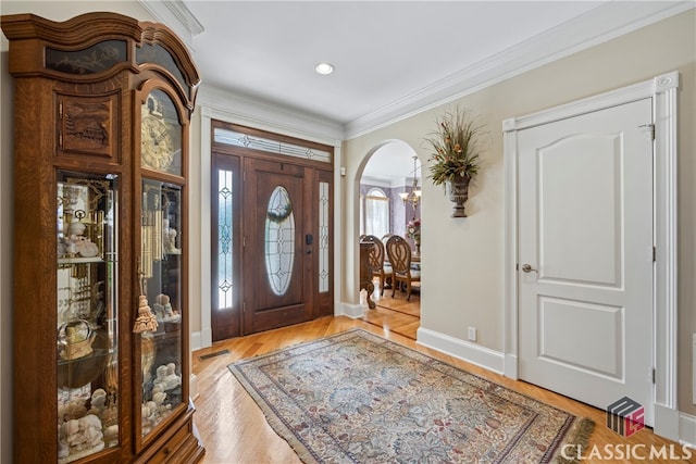 foyer featuring ornamental molding and light hardwood / wood-style floors