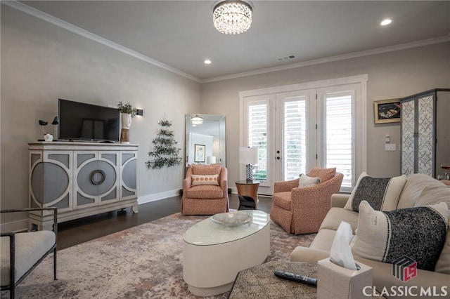 living room with an inviting chandelier, hardwood / wood-style flooring, and ornamental molding