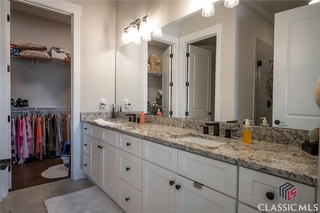 bathroom featuring vanity, a shower with door, and tile patterned floors