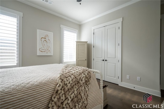 bedroom featuring ornamental molding, dark hardwood / wood-style flooring, and a closet