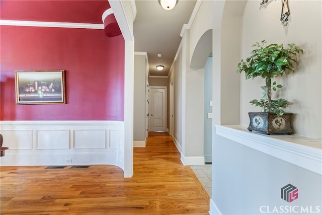 hall featuring crown molding and light hardwood / wood-style floors