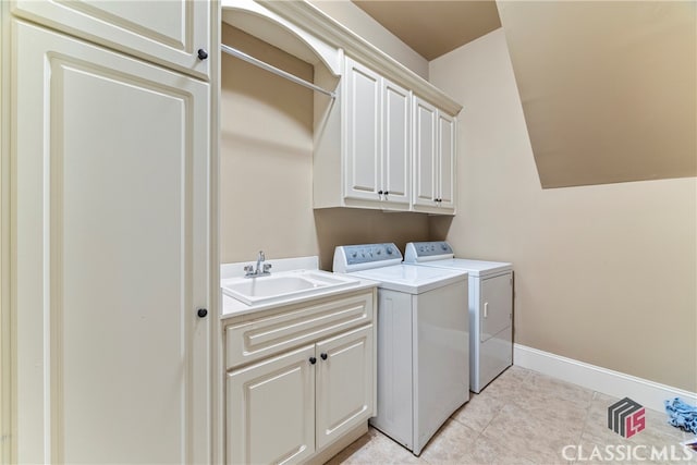 clothes washing area with cabinets, sink, light tile patterned floors, and washing machine and clothes dryer